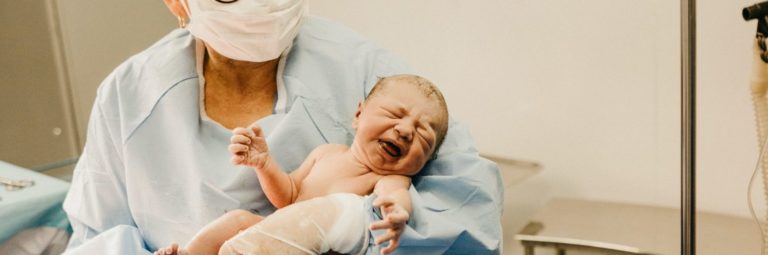 newborn baby with nurse and mother