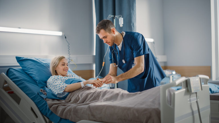 male nurse connects heart rate monitor to patient's finger